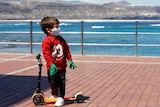 A child plays with a scooter at promenade of Las Canteras beach after restrictions were partially lifted.