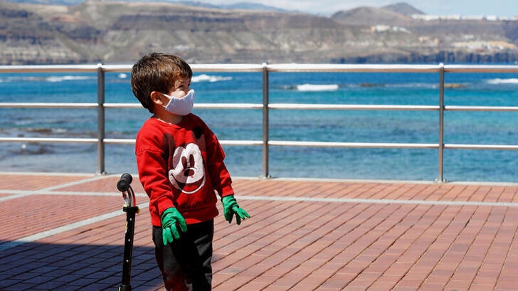 A child plays with a scooter at promenade of Las Canteras beach after restrictions were partially lifted.