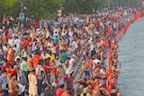 Crowds of people gather near the river bank