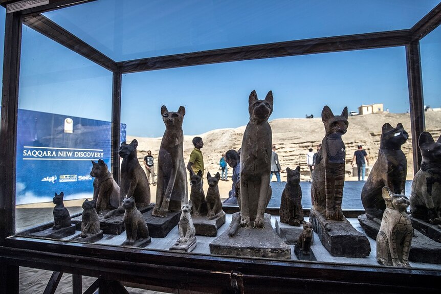 Statues of cats are displayed.