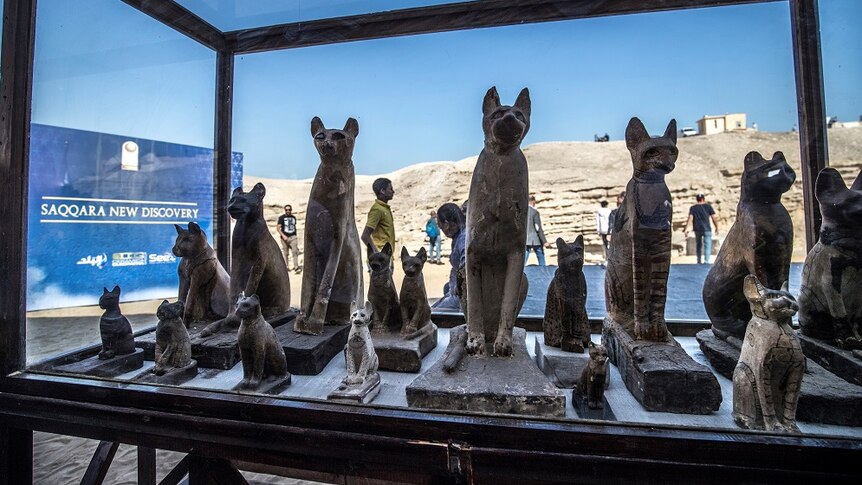Statues of cats are displayed.