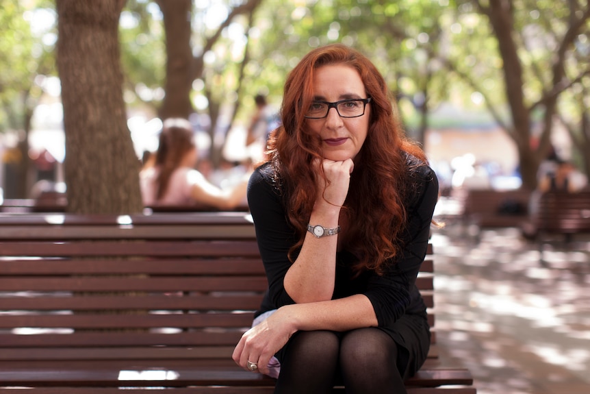 A woman sitting on a park bench.