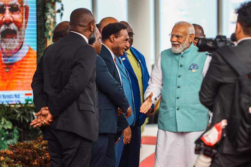 India's Prime Minister Narendra Modi goes to shake hands with PNG Prime Minister James Marape. 