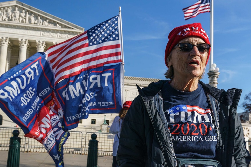 Activists demonstrate their support for President Donald Trump holding signs and US flags in front of the Supreme Court.