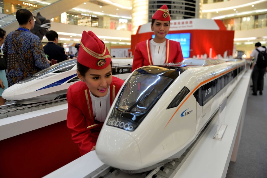 Indonesian models view scale models of Chinese-made bullet trains on exhibition at a Jakarta shopping mall