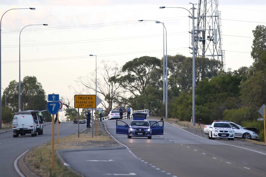 A wide shot showing Leach Highway in Welshpool with police vehicles and a crashed motorcycle and car in the distance.