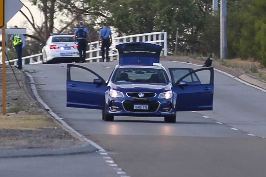 A wide shot showing Leach Highway in Welshpool with police vehicles and a crashed motorcycle and car in the distance.