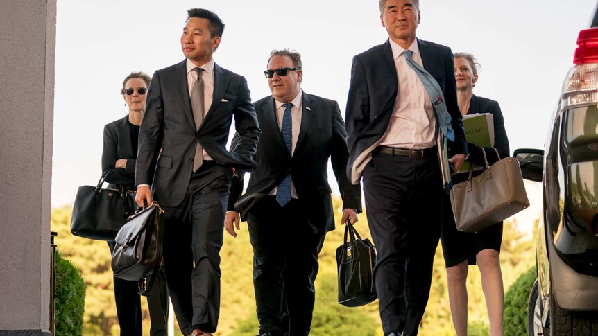 Secretary of State Mike Pompeo walks with other diplomats