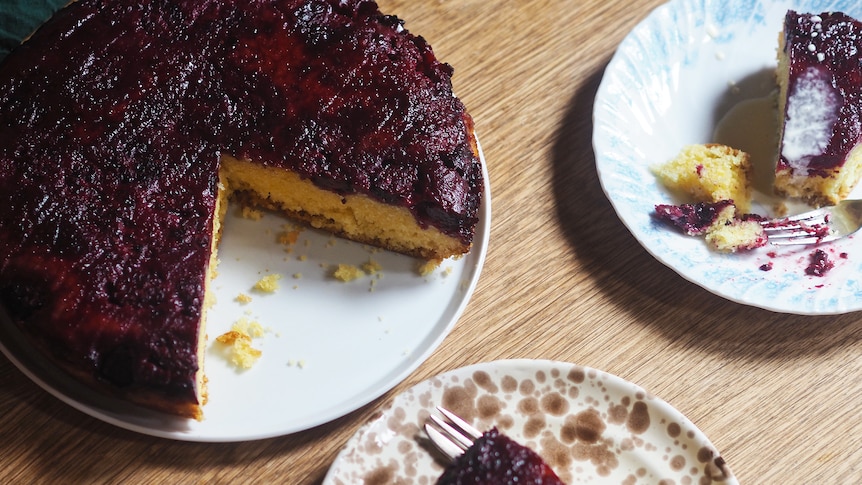 A blackberry upside-down cake with two pieces on plates on a table, an easy dessert recipe.
