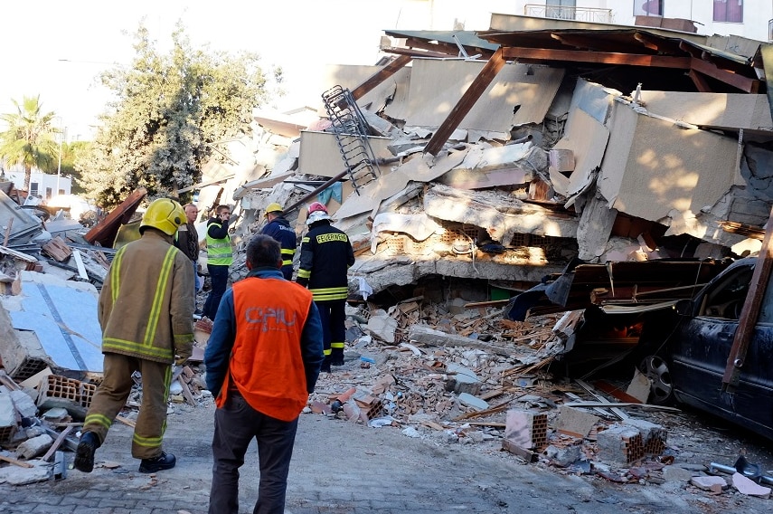Firefighters stand next to a damaged building after a magnitude 6.4 earthquake in Durres.