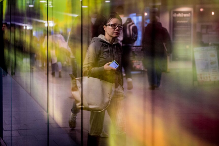 A woman walking along a street in reflection