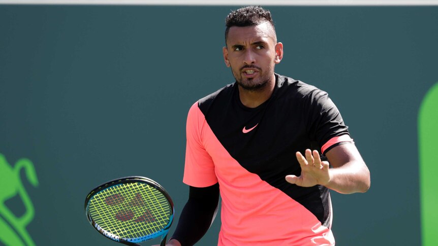 Nick Kyrgios puts his hand up in the direction of the chair umpire at the Miami Open.