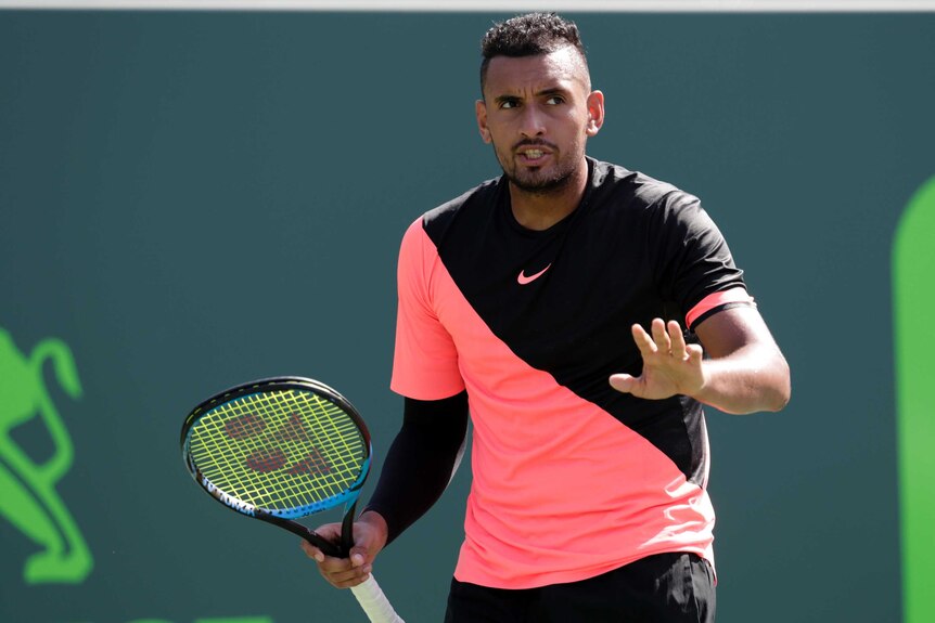 Nick Kyrgios puts his hand up in the direction of the chair umpire at the Miami Open.