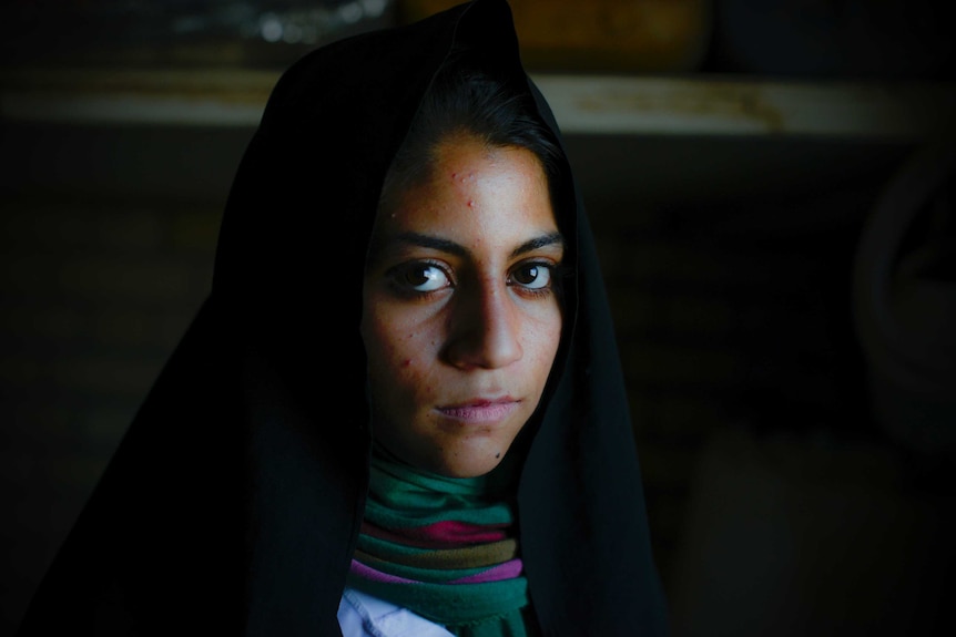 A portrait of a young female Afghan refugee