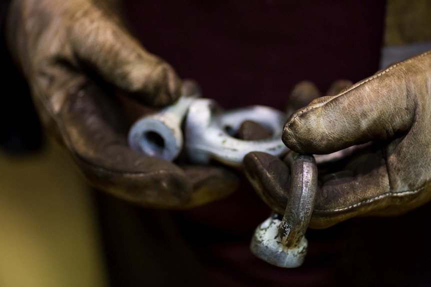 Bolts and fixtures in a worker's gloved hand