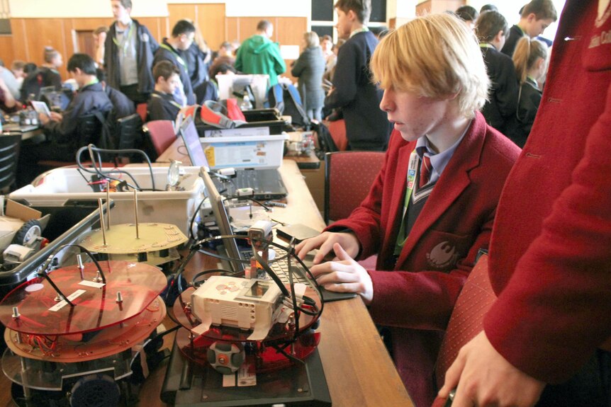 Lachlan Angus with his robots at RoboCup