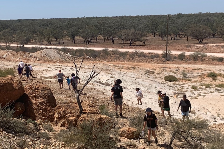 A group of people walking around the rocky outcrops of a Queensland town.