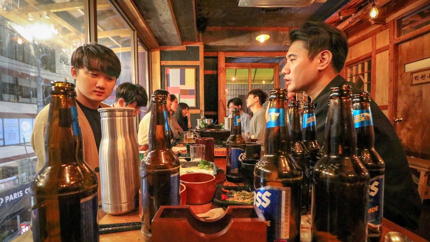 Students sit around a table at a bar drinking