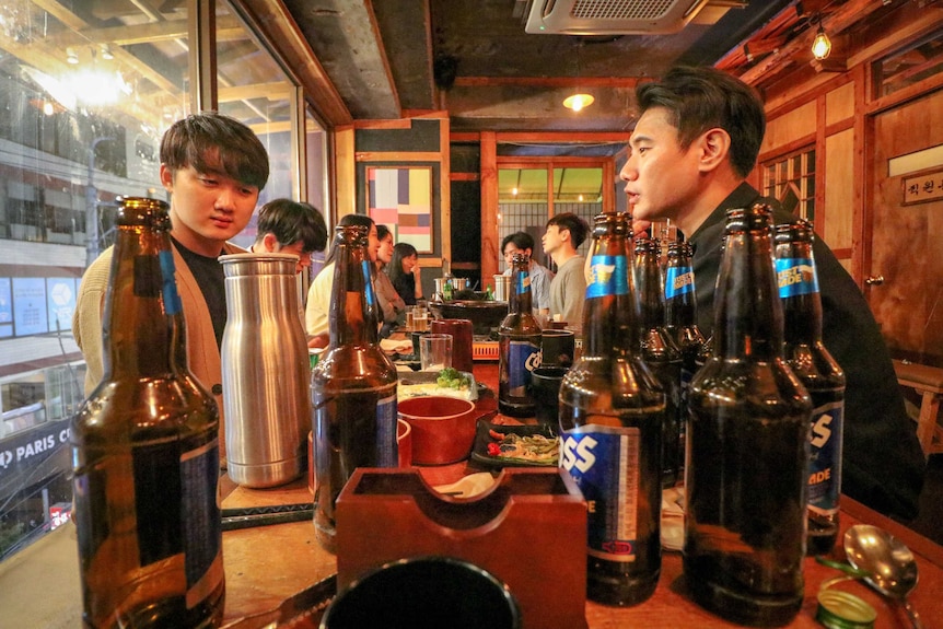 Students sit around a table at a bar drinking