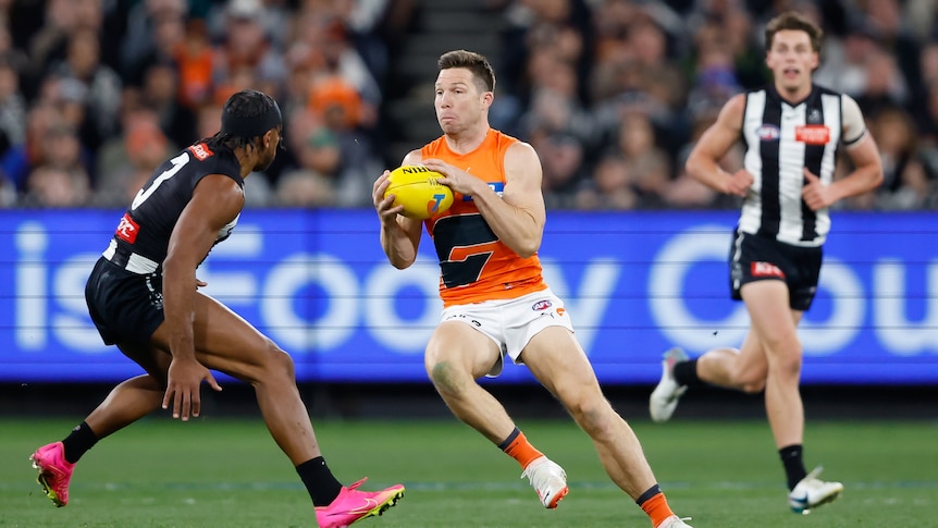 GWS captain Toby Greene runs with the ball towards a Collingwood defender at the MCG.