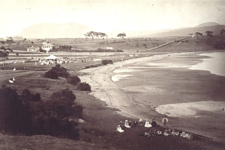 Sepia photo of Cornelian Bay with people in Victorian dress having a picnic on the ground