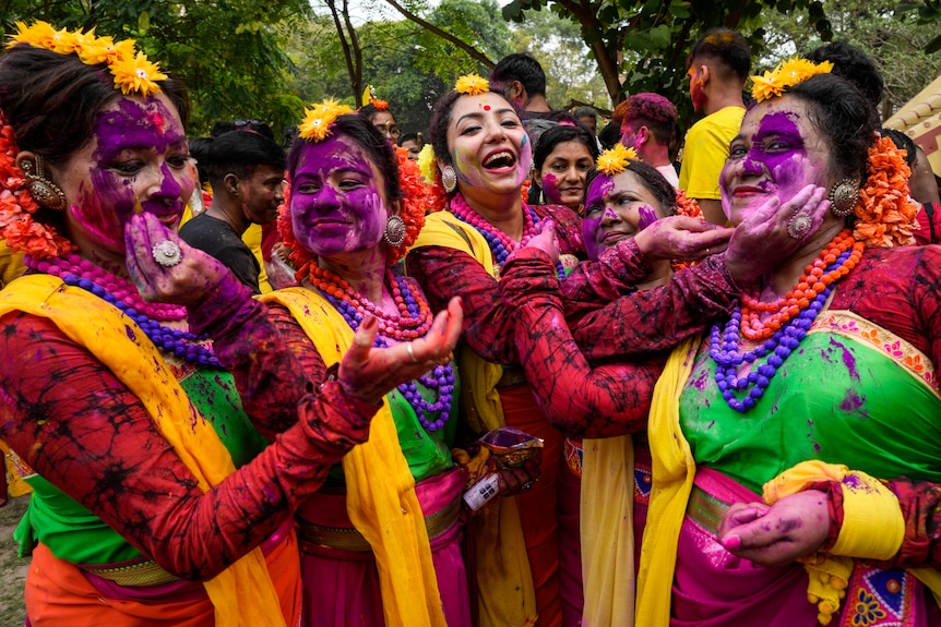 A colourful group of traditionally dressed Indian women celebrate the Holi festival
