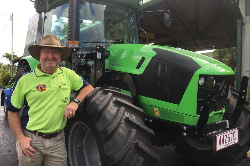 Greg Dennis poses beside the new tractor he plans to drive to Cairns.