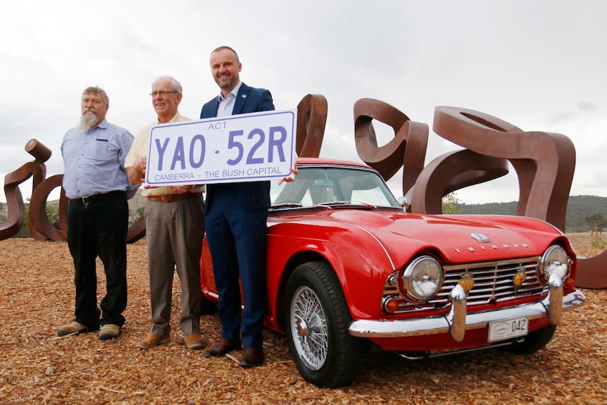 Chief Minister Andrew Barr with a giant novelty number plate reading 'Canberra - the bush capital'.