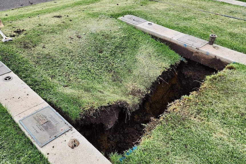 A hole in the ground that appears to be collapsing in at the sides.