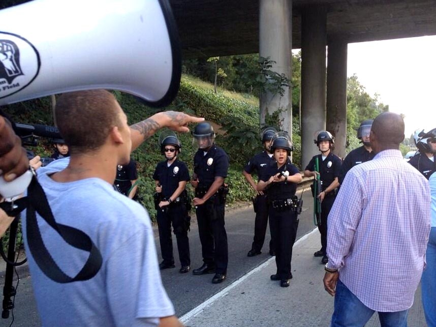 LAPD officers stand in front of Trayvon Martin supporters.