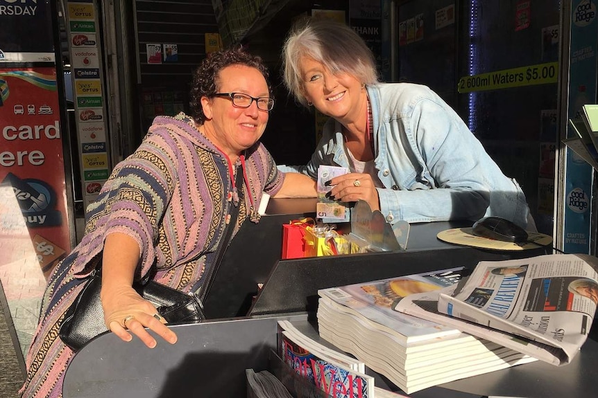 Two women at counter of newsagency