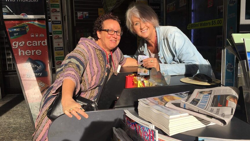 Two women at counter of newsagency