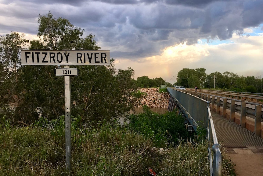 A sign in front of river crossing