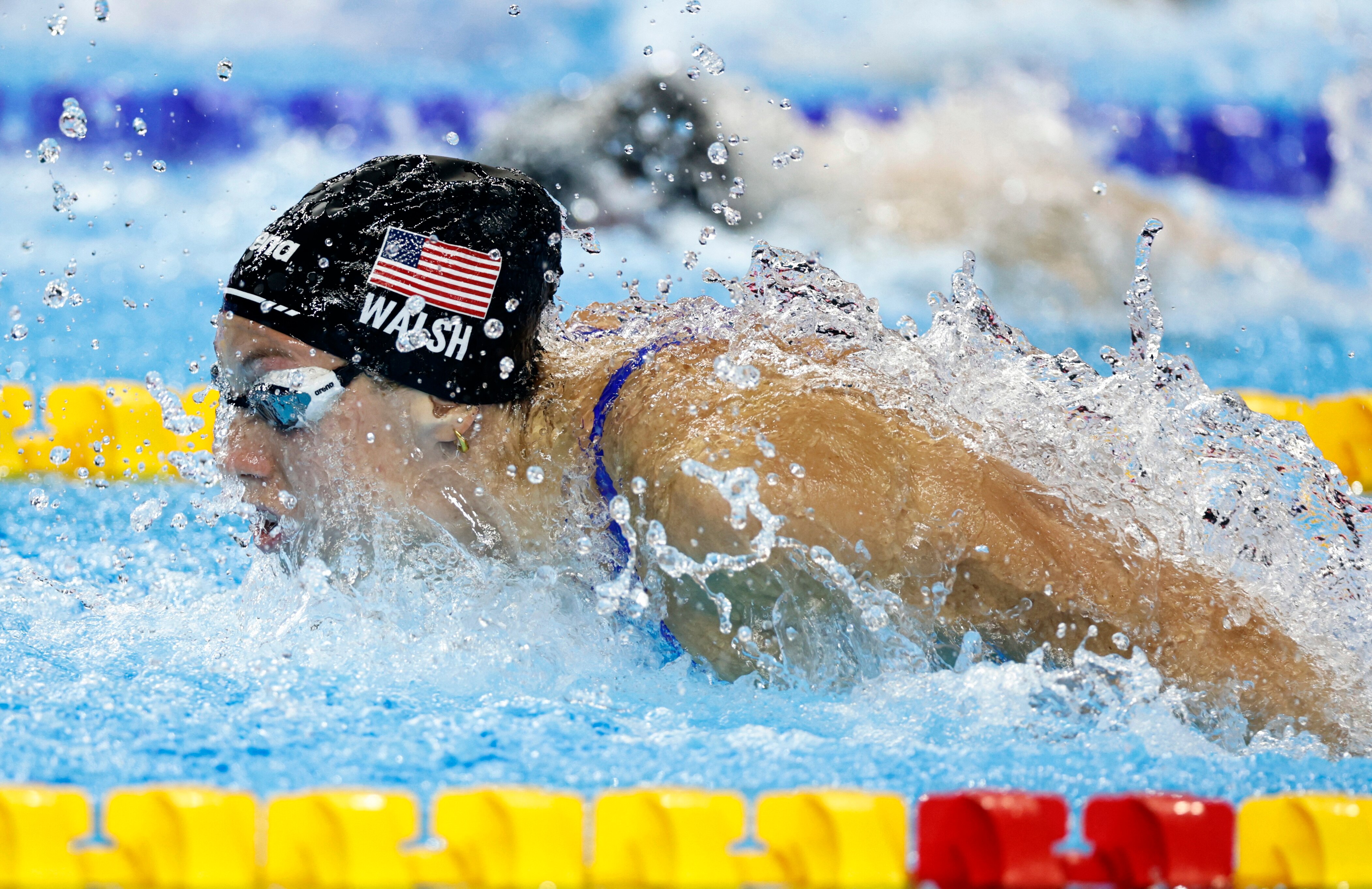 A woman swimming butterfly in a pool.
