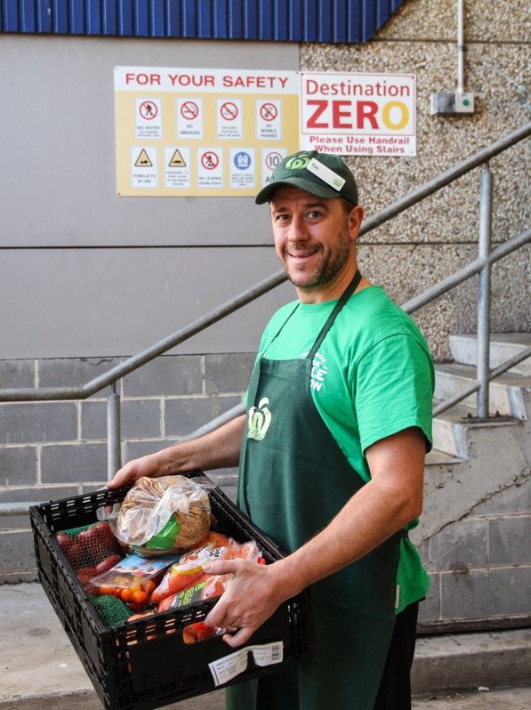 A Woolies guy holds a tray of rescued food.