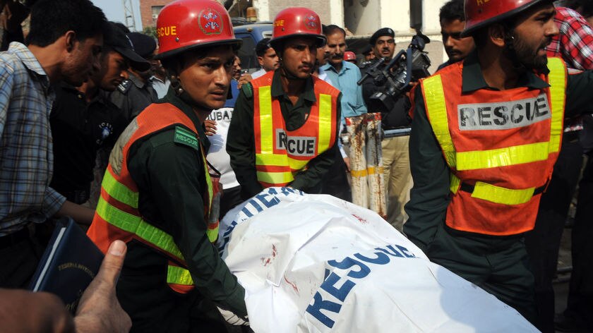 Pakistani volunteers remove a body from the Federal Investigation Agency (FIA) building after gunmen