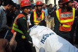 Pakistani volunteers remove a body from the Federal Investigation Agency (FIA) building after gunmen