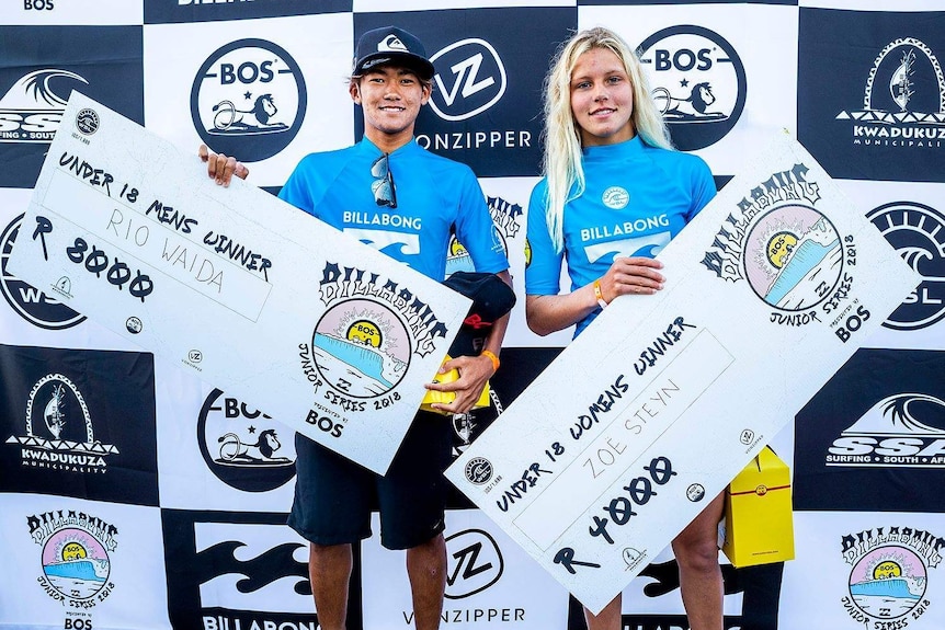 Under-18 surfers Rio Waida and Zoe Steyn with their winner's cheques at the Ballito Pro in South Africa.