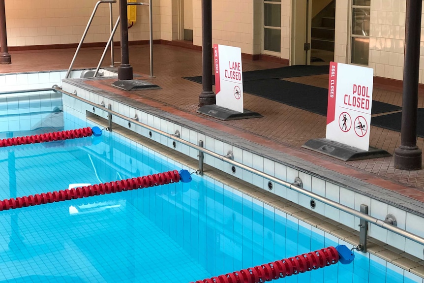 A shot of the end of the lanes inside Melbourne City Baths shows "Lane Closed" and "Pool Closed" signs.