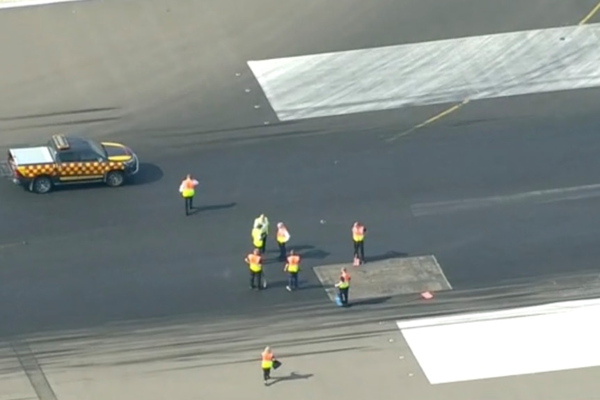 Engineers work on a section of runway.