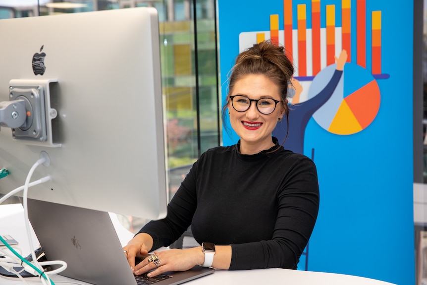 Employee Kirsti Taylor sits at her computer at her employer's new office.