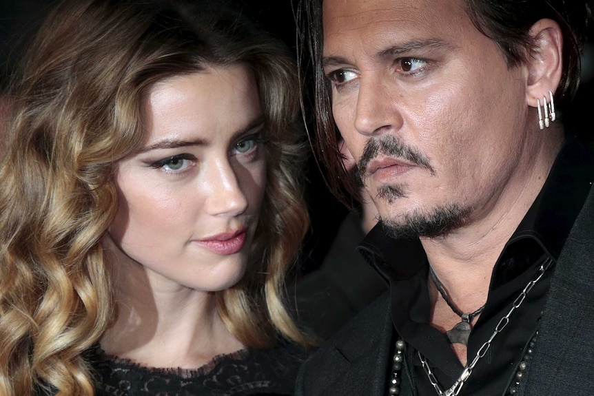 A tight photo of actors Amber Heard and Johnny Depp at a red carpet event.