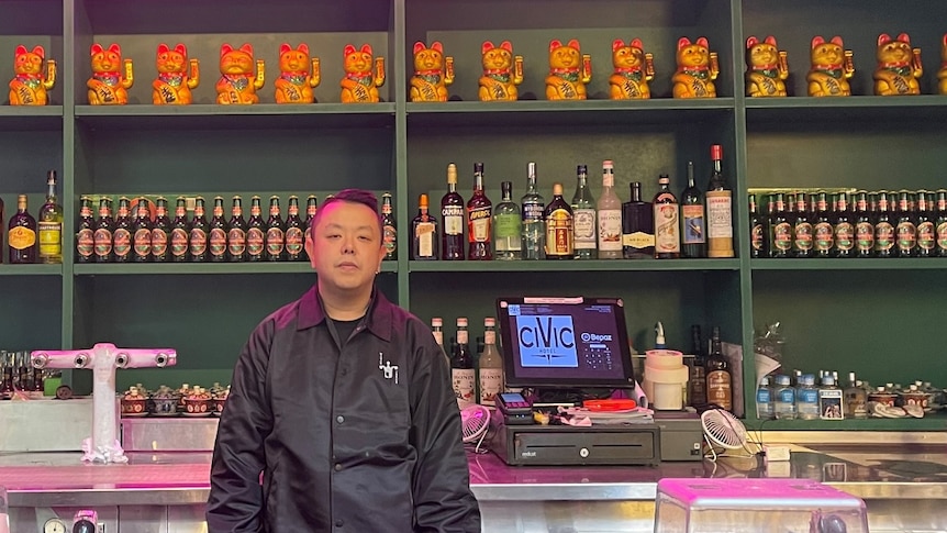 a man standing in front of a bar