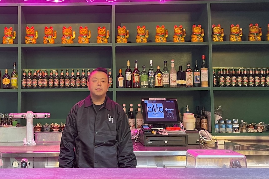 a man standing in front of a bar