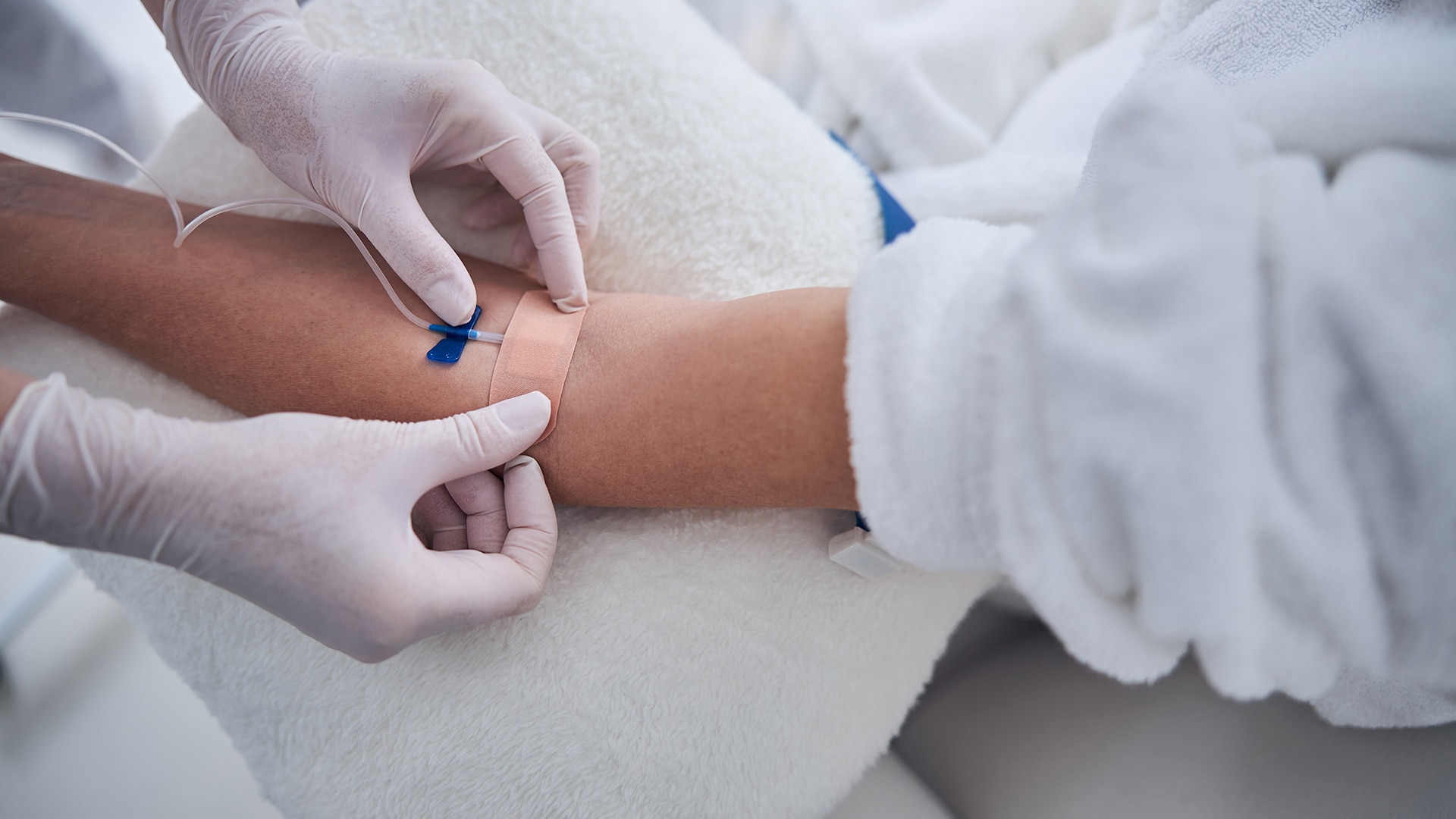 Doctor administers intravenous line into a patient's arm