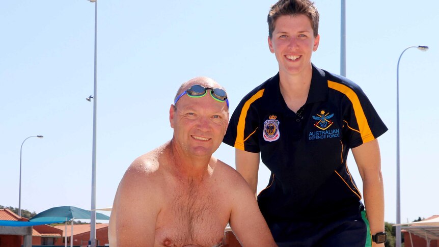 Petty Officer Ian McCracken and Lieutenant Amy Beal of the Australian Defence Force on the edge of a pool.