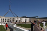 Woman stands outside Parliament House, Canberra.