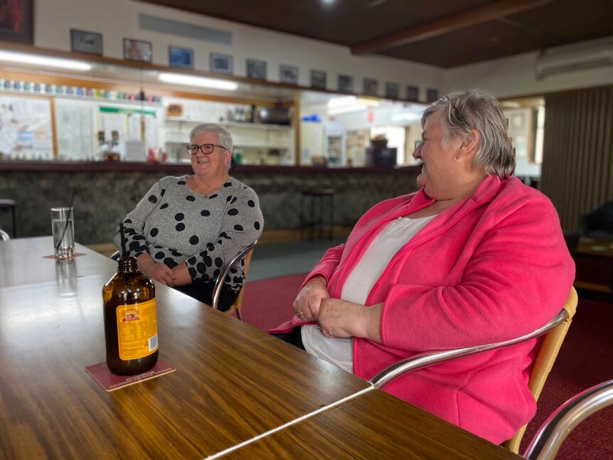 Two older women sit smiling at an RSL bar.