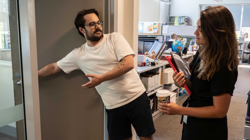 Man holding door open for woman