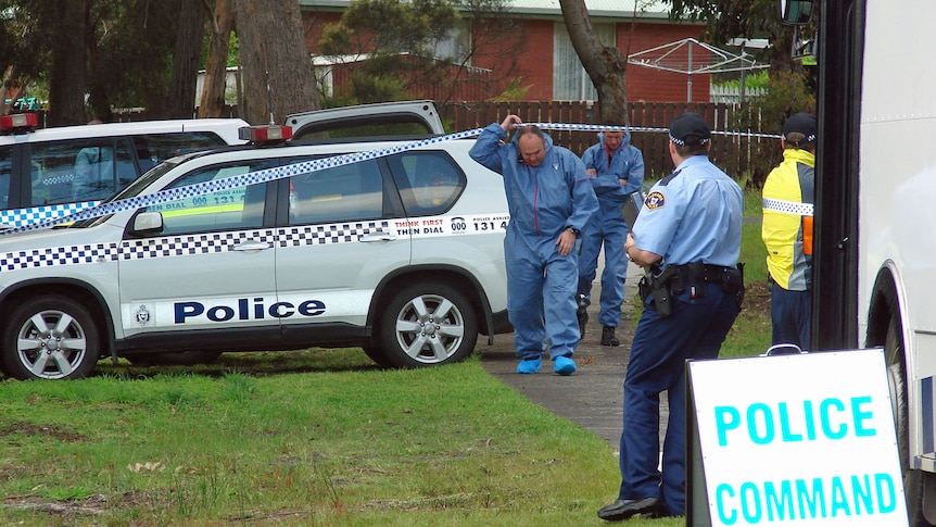 Forensic police leave a park where a baby's body was found at Kingston, Tasmania.